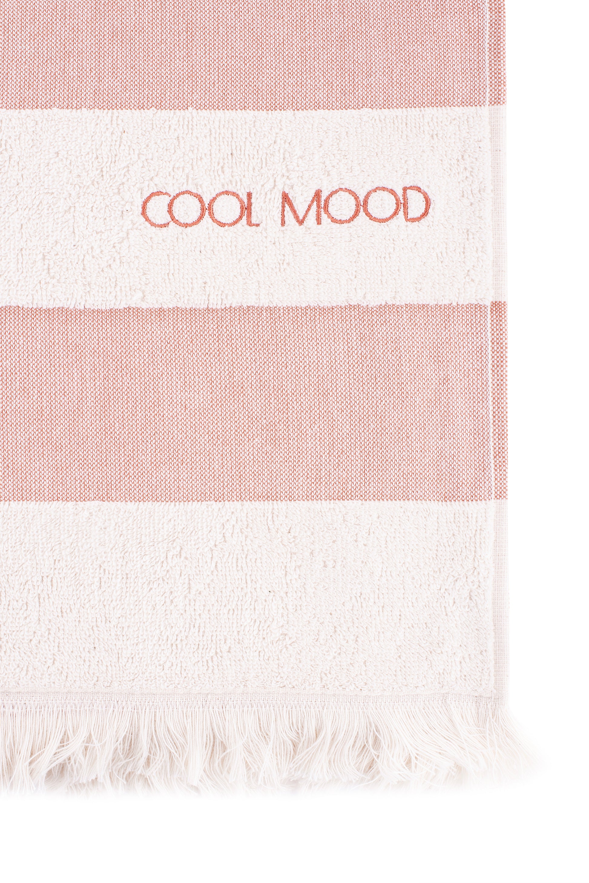 Beach towel in rust shade, with soft terry stripes, eyelash fringing detail and embroidery in rust.