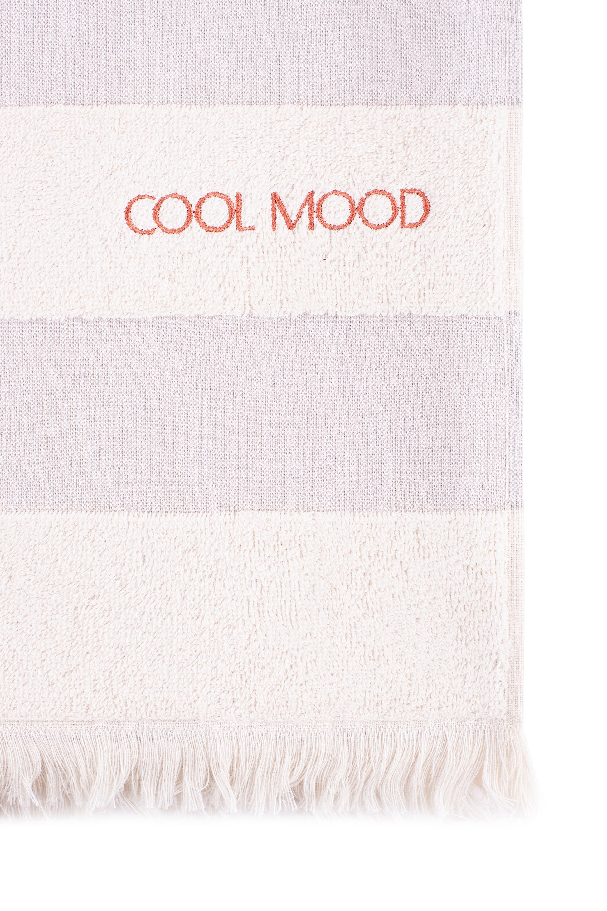 Beach towel in grey shade, with soft terry stripes, eyelash fringing detail and embroidery in rust
